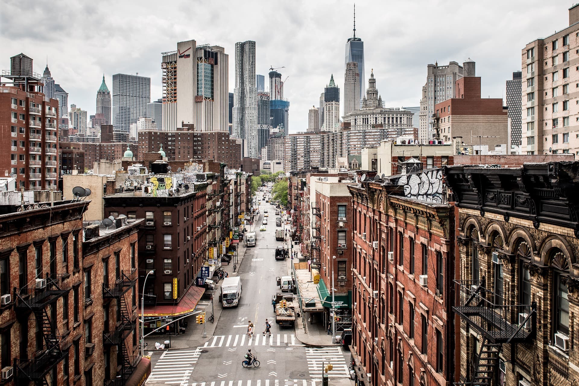 View of brooklyn with manhattan in the background. The skyscrapers are covered by a dark overlay, the red brick building in the foreground are clear.
